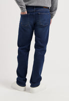Sustainable MUD Jeans jacket and jeans in light blue denim, crafted from organic cotton, paired with white sneakers.