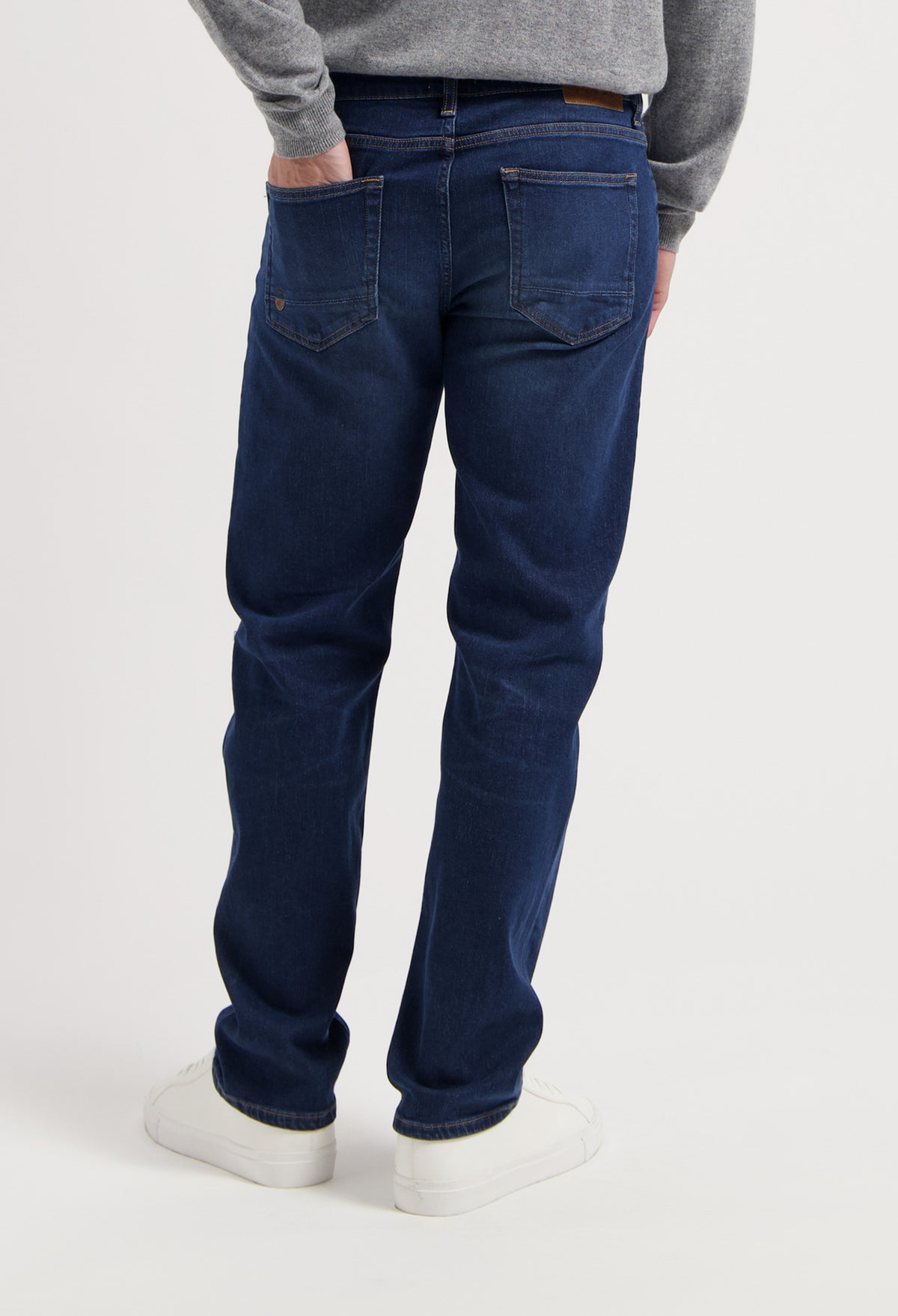 Sustainable MUD Jeans jacket and jeans in light blue denim, crafted from organic cotton, paired with white sneakers.