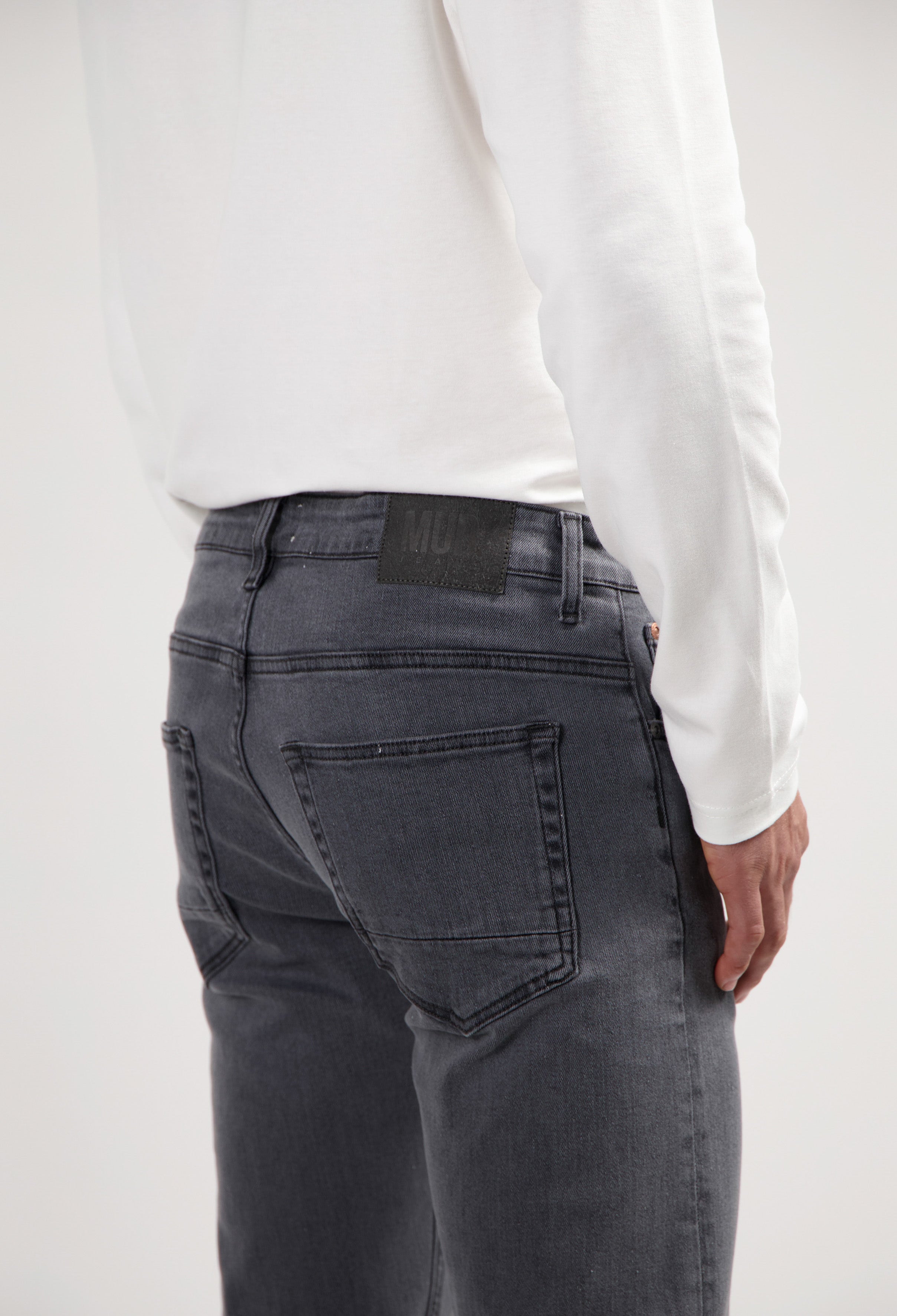 Sustainable MUD Jeans in deep blue denim, highlighting ethical fashion with a classic fit, paired with white sneakers.