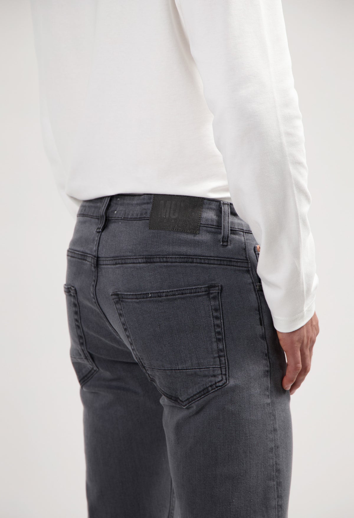Sustainable MUD Jeans in deep blue denim, highlighting ethical fashion with a classic fit, paired with white sneakers.