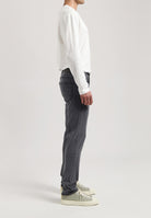 Sustainable MUD Jeans in dark denim, crafted from ethical materials, paired with a light gray sweater.