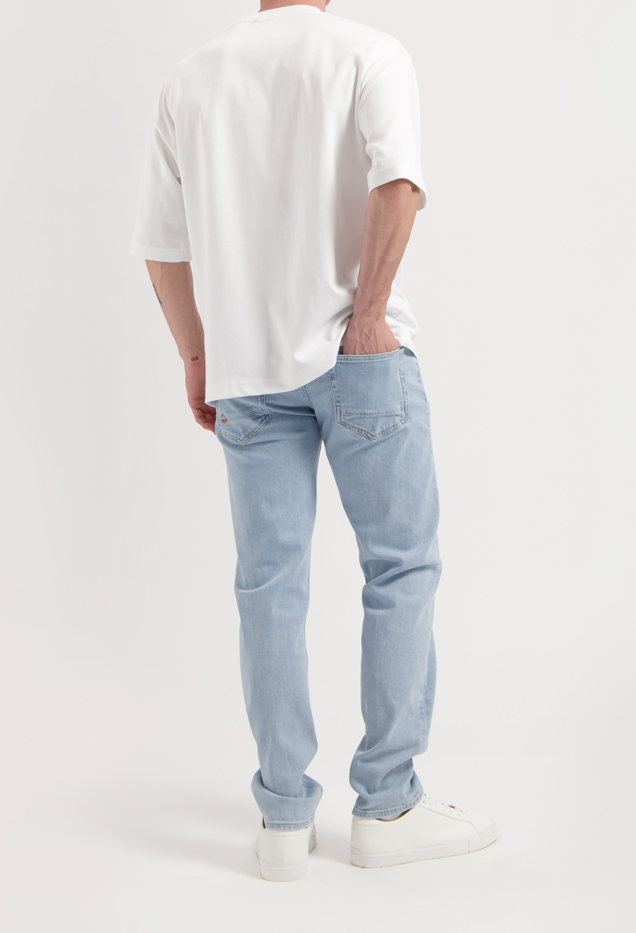 Sustainable MUD Jeans in dark black denim, crafted from ethical materials, shown in a slim fit paired with classic loafers.