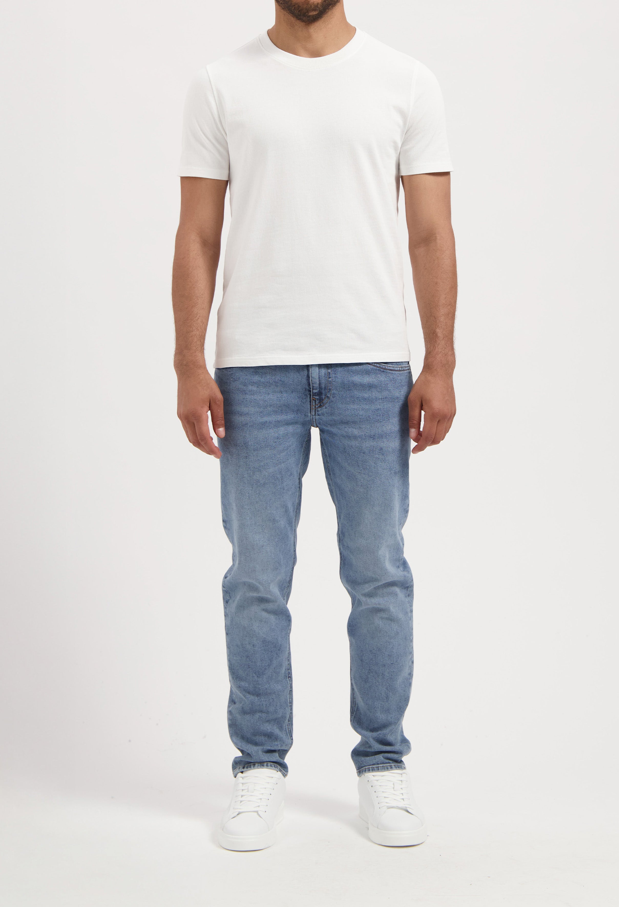 Sustainable MUD Jeans beige shorts, crafted for ethical fashion, paired with casual gray shirt for modern style.