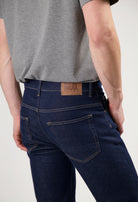 Mud Jeans sustainable light blue denim, crafted ethically from organic cotton, paired with a simple white long-sleeve shirt.