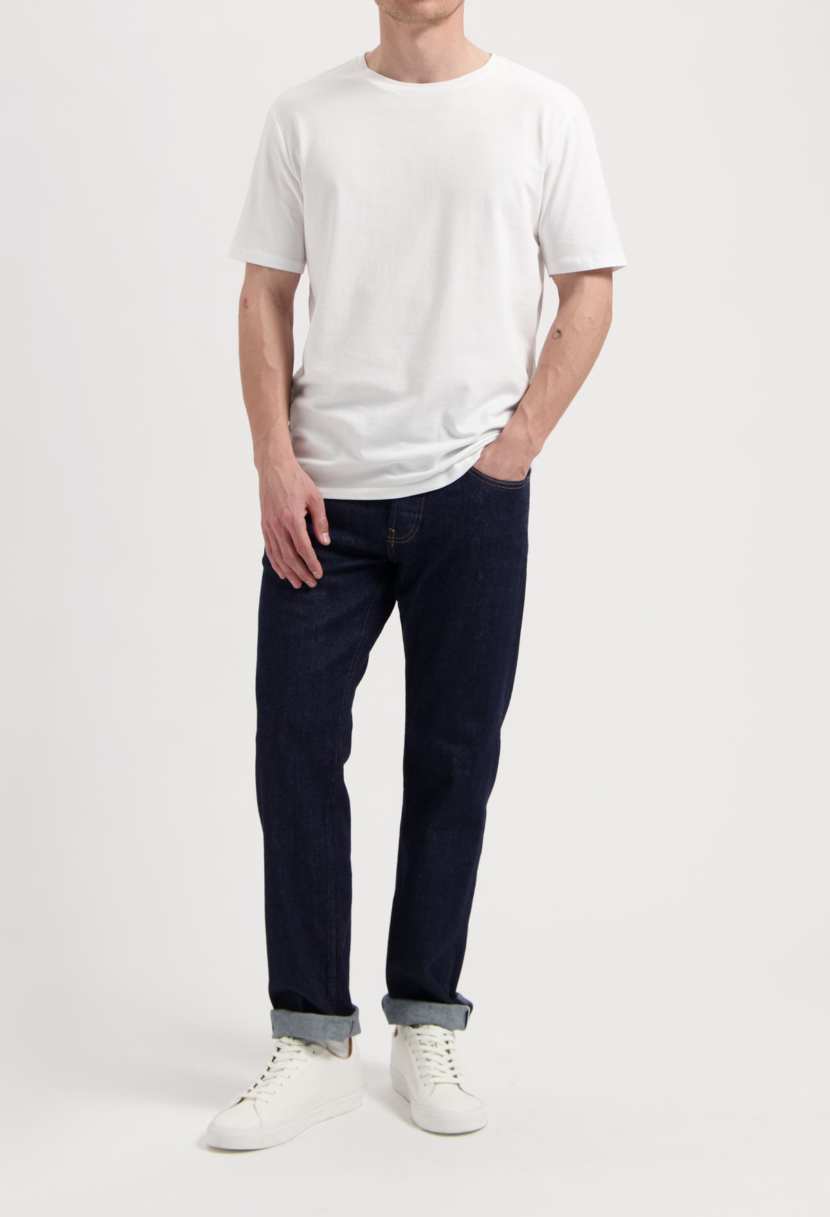 Sustainable MUD Jeans ensemble with dark denim jacket, light blue jeans, and white sneakers, embodying ethical fashion.