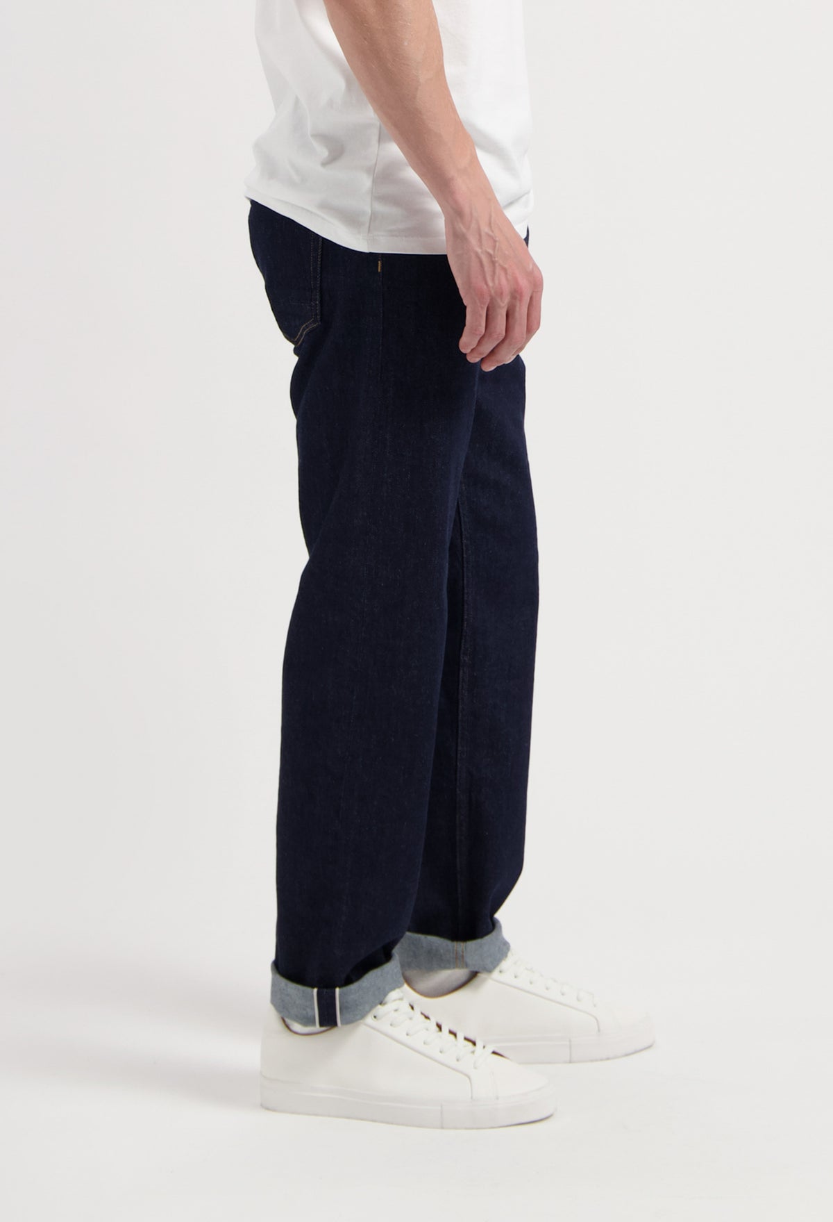 Sustainable MUD Jeans crafted from organic cotton, featuring dark blue denim in a regular fit, paired with a gray sweater.