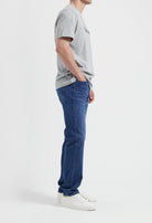 Sustainable MUD Jeans in deep blue denim paired with a classic fit, showcasing ethical fashion with a gray sweater.