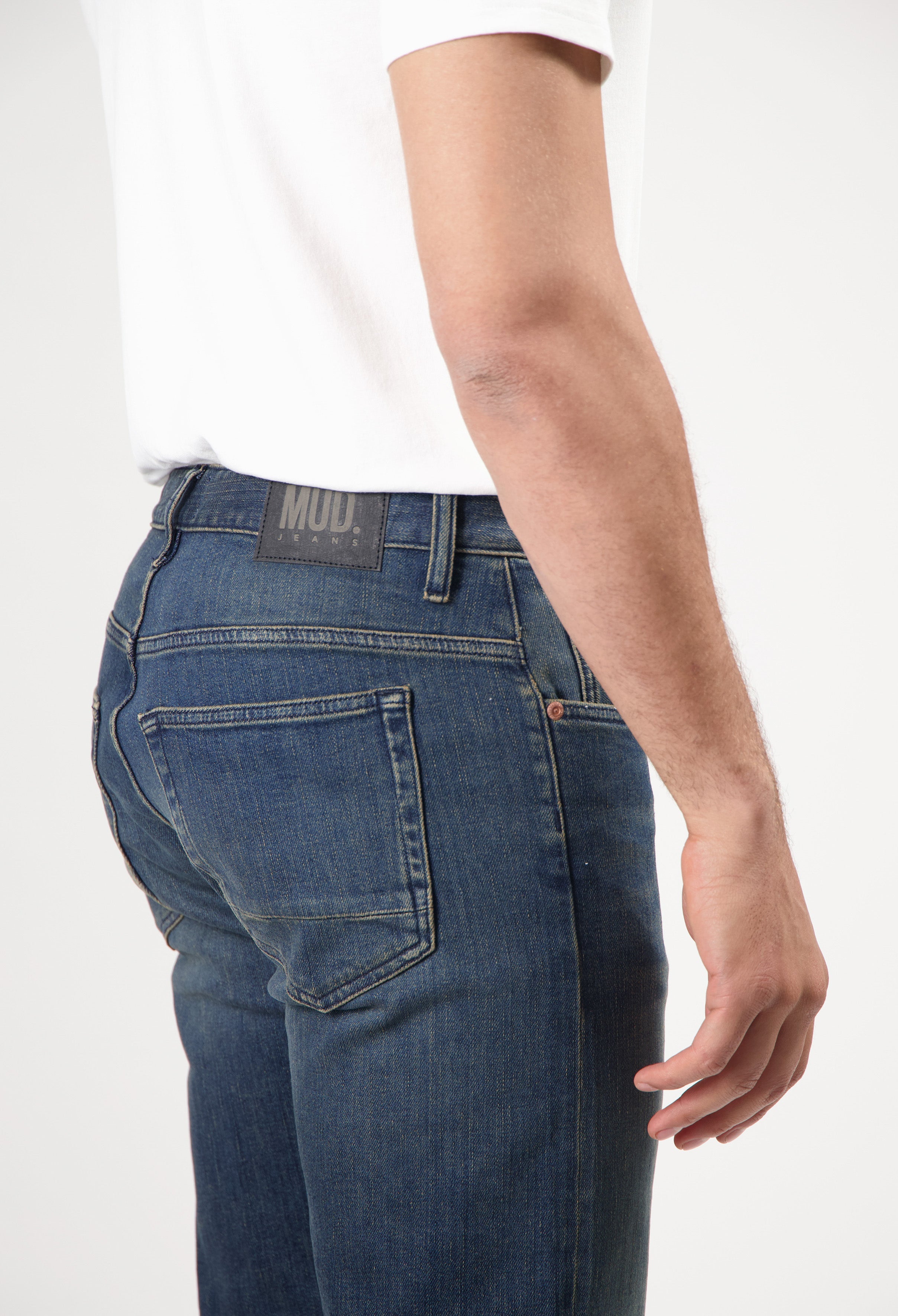 Sustainable MUD Jeans in light blue, crafted from organic cotton, featuring a classic fit, paired with black shoes.