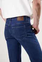 Sustainable MUD Jeans outfit in blue denim featuring an ethical shirt and classic fit jeans, paired with white sneakers.