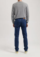 Sustainable MUD Jeans in dark denim, ethically crafted for a modern fit, styled with white shirts and minimalist footwear.