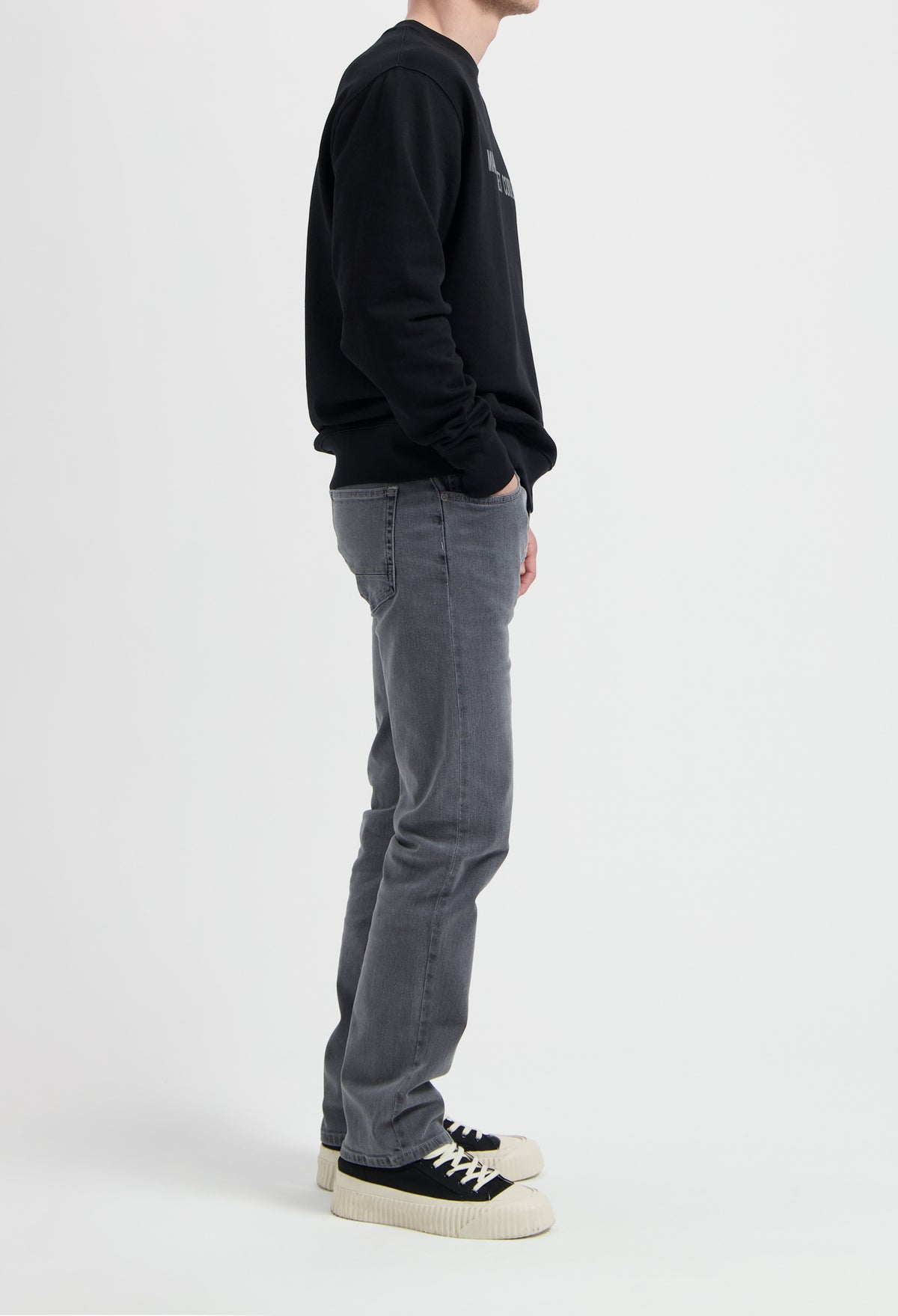 Sustainable MUD Jeans in light blue denim, crafted ethically from organic cotton, shown paired with white sneakers.