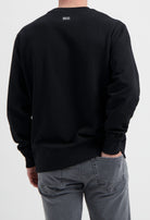 Sustainable MUD Jeans in gray worn with a black ethical sweatshirt, showcasing eco-friendly fashion choices.