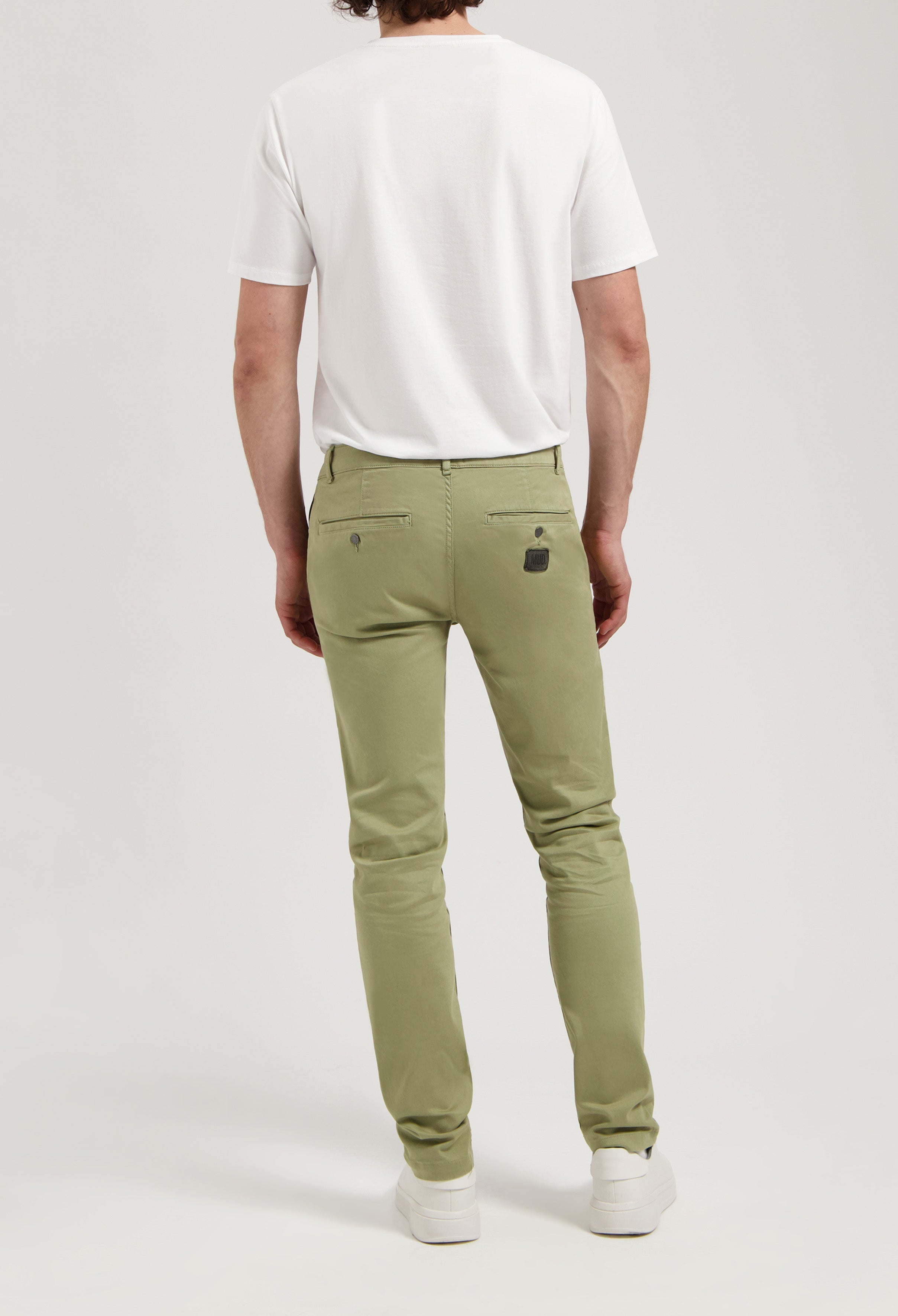 Sustainable MUD Jeans in dark denim, crafted ethically from organic cotton, featured with casual style sneakers.