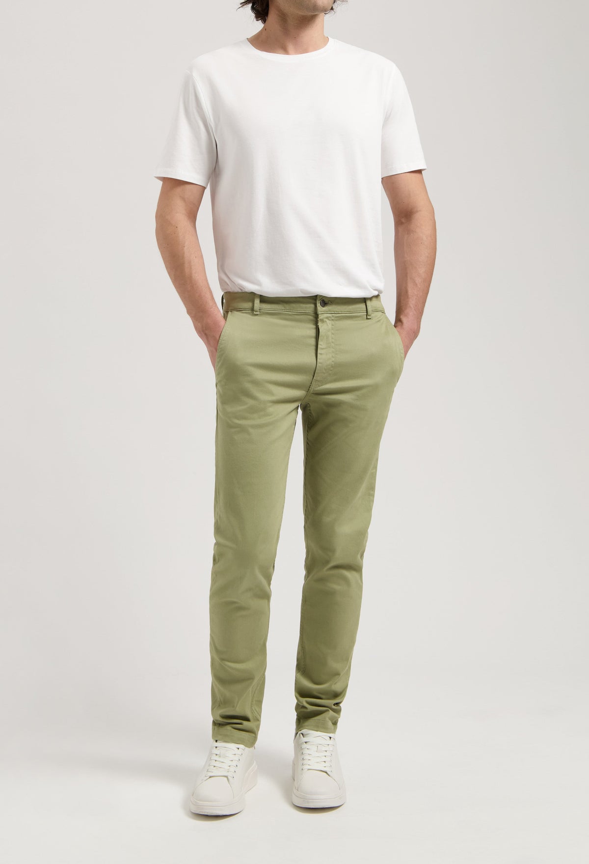 Sustainable MUD Jeans in black denim, crafted ethically from organic cotton, styled with a plain white T-shirt.