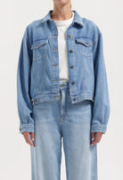 Light blue denim jacket and jeans set, featuring classic button-down design and relaxed fit, worn with a basic white top.