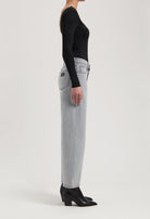 High-waisted straight-leg gray jeans made from denim, paired with a black long-sleeve top and black pointed boots.