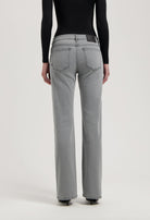 Gray high-waisted denim jeans with straight-leg fit, featuring detailed stitching and worn with a black long-sleeve top.
