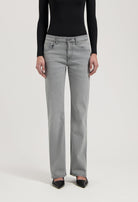 Gray straight-leg jeans paired with a sleek black long-sleeve top and pointed black heels for a modern look.