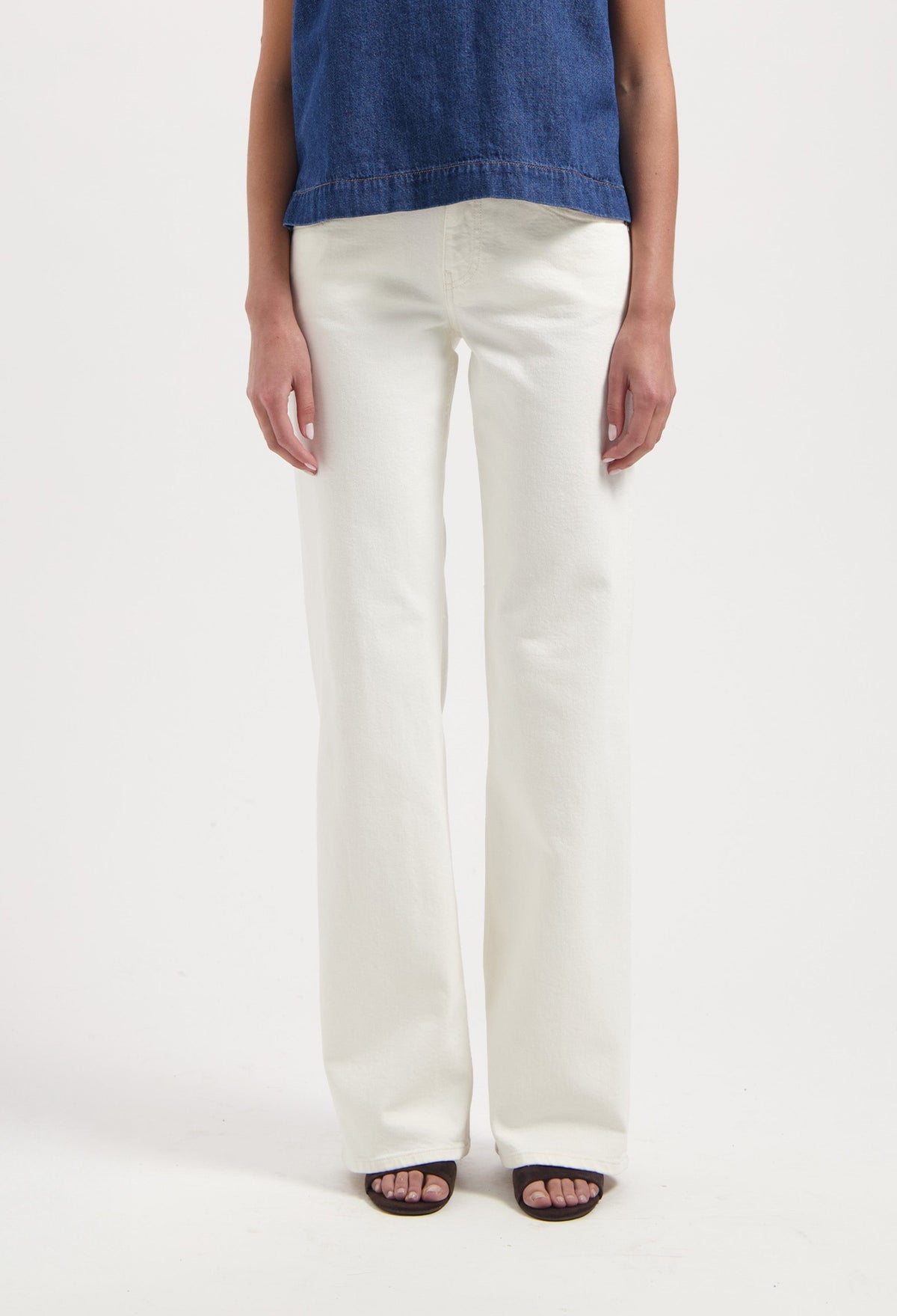 Wide-leg white jeans styled with an indigo denim sleeveless top, showcasing a minimalistic and modern fashion ensemble.