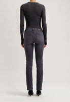 Back view of dark gray slim-fit denim jeans with a fitted long-sleeve charcoal top, highlighting sleek and modern fashion.