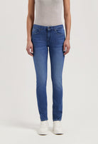 Blue slim-fit denim jeans paired with a light gray sleeveless top, completed with white sneakers, showcasing casual style.
