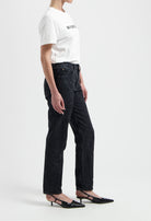 Casual white cotton t-shirt paired with loose-fit black jeans and pointed black heels, highlighting a trendy everyday outfit.