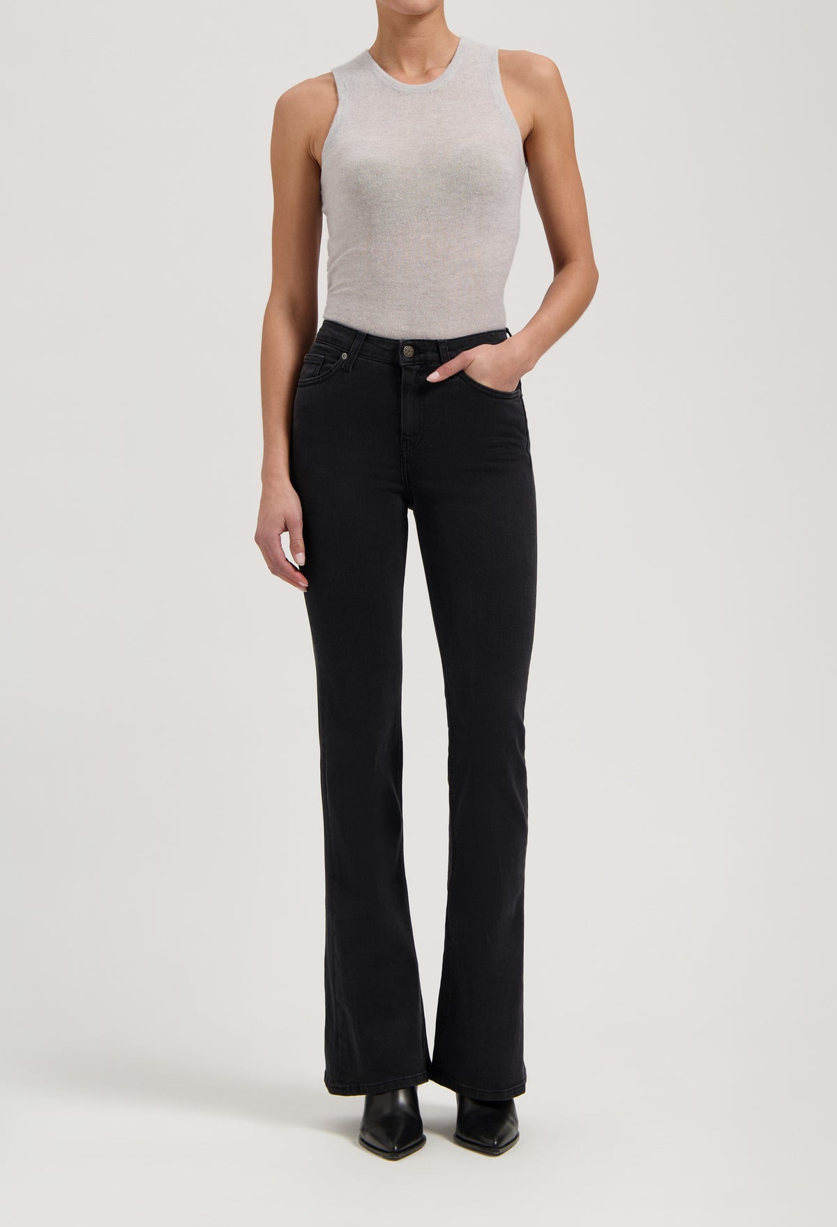 Ribbed gray sleeveless top paired with black high-waisted bootcut jeans and black ankle boots.