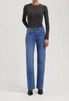 Dark gray fitted long-sleeve top paired with classic blue straight-leg jeans and black pointed-toe ankle boots.