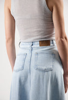 Light blue denim MUD Jeans skirt with high waist and back pockets, paired with a sleeveless light gray top.