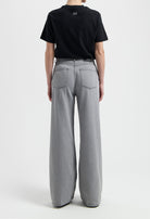 Sustainable MUD Jeans in beige, crafted from organic cotton, offering a tailored fit, paired with a gray T-shirt.